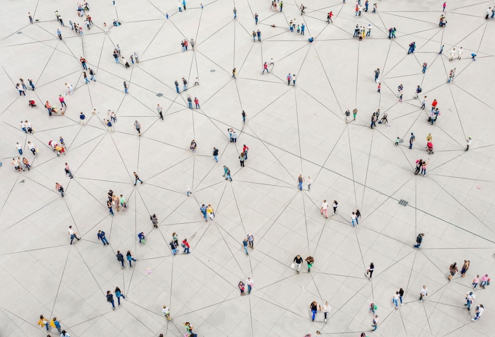 Aerial view of people walking around connected with lines to convey a network