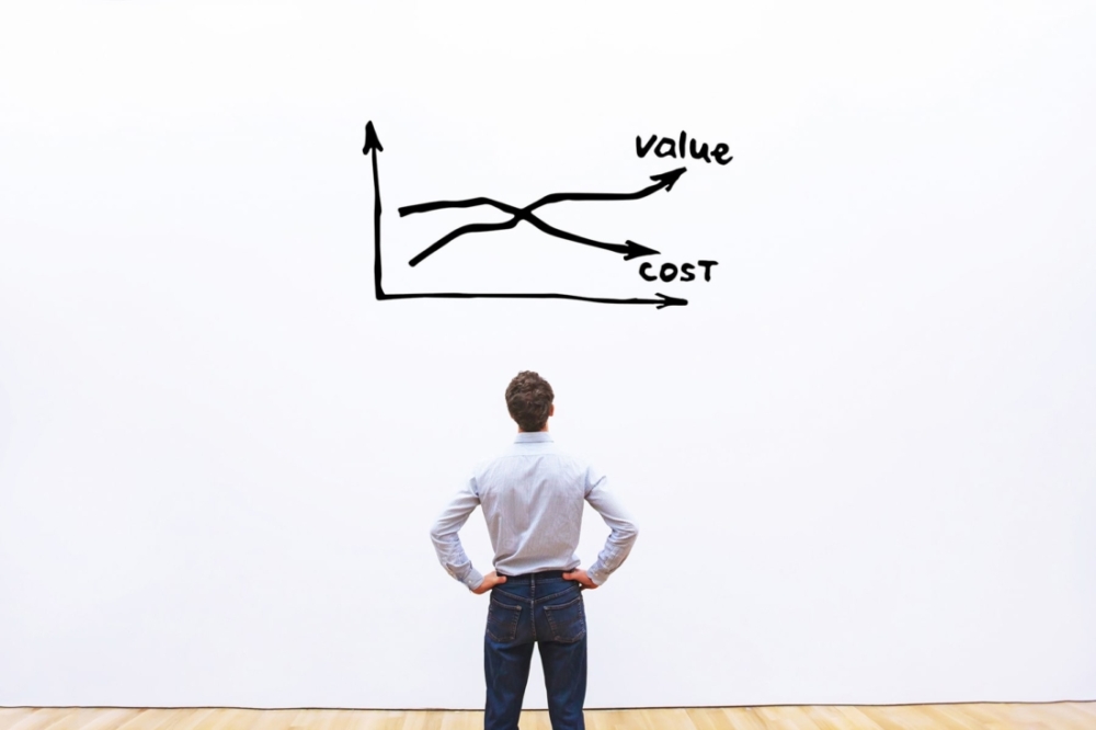 Man looking at graph of ROI with decreasing cost and increasing value