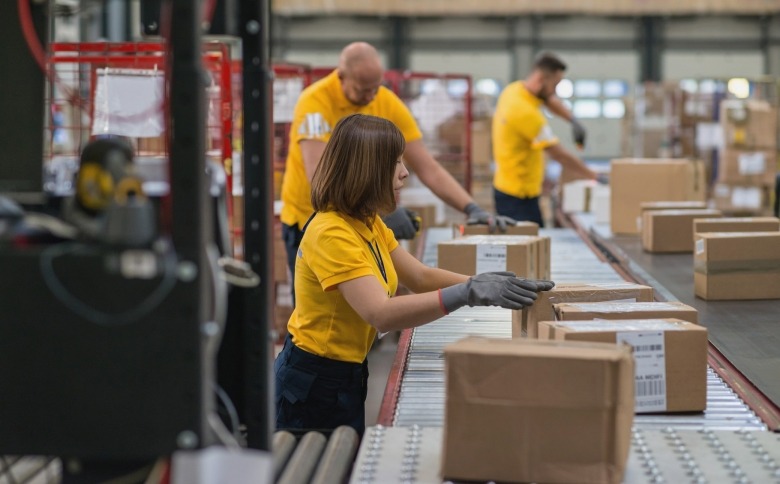 Employees on assembly line inspecting boxes