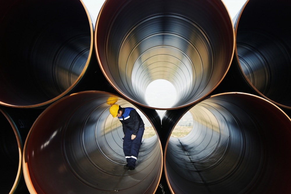 A man inspecting industrial pipes