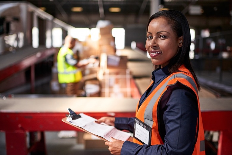 Female inspector holding clipboard in warehouse