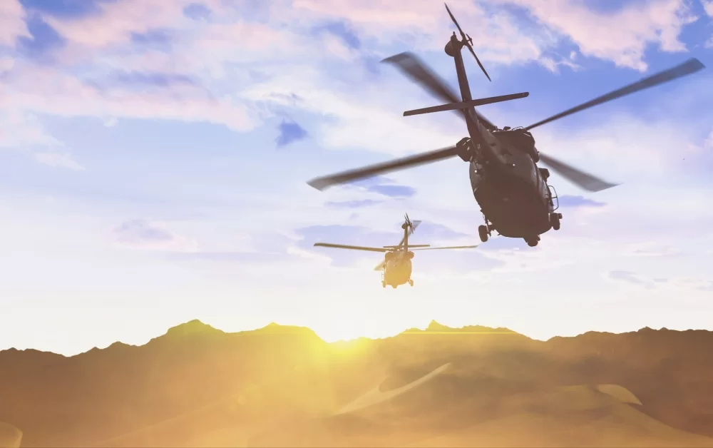 Two Aerospace defense helicopters flying over desert